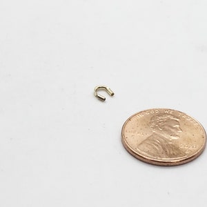 Op de afbeelding: Een kleine gouden springring, ongeveer ter grootte van een Amerikaanse cent, voor het maken van sieraden.