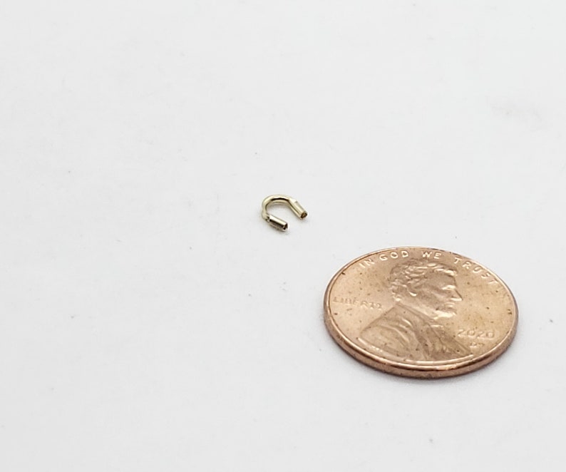 Op de afbeelding: Een kleine gouden springring, ongeveer ter grootte van een Amerikaanse cent, voor het maken van sieraden.