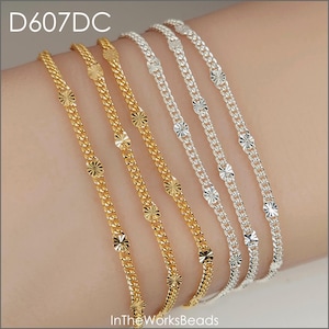 Puede incluir: Primer plano de varias pulseras de cadena delicadas de oro y plata. Cada pulsera presenta un diseño de eslabones de cadena con acentos circulares decorativos espaciados uniformemente. Las pulseras se muestran sobre una superficie de tono claro. El texto "D607DC" y "InTheWorksBeads" son visibles.