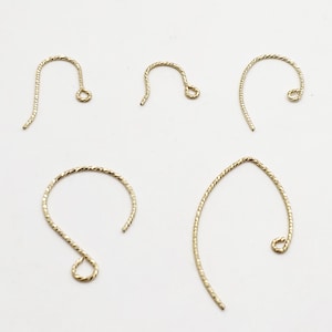 May include: Five gold-colored earring hooks with a textured, twisted design. The hooks are in various shapes, including a curved fish hook style and a circular design. The hooks are displayed on a white background.