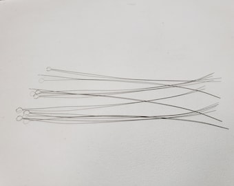 May include: A set of thin, silver-colored, looped wires, likely used for jewelry making or crafting.