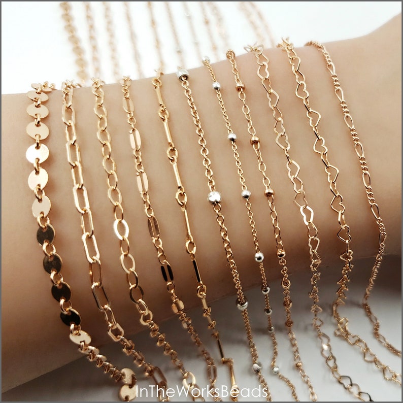 May include: A collection of gold chain bracelets with different link styles, including a coin chain, a cable chain, a box chain, a curb chain, a heart chain, and a bead chain.