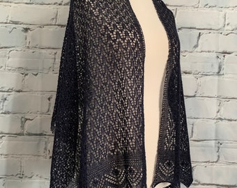May include: A dark blue lace shawl with a delicate pattern. The shawl is draped over a white mannequin.