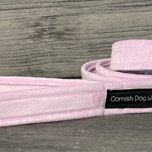 May include: A pink dog lead with a black label that says "Cornish Dog Wear" and a silver clip.