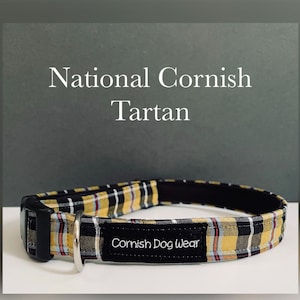 May include: A black dog collar with a yellow and black tartan pattern and a black label that says "Cornish Dog Wear". The collar is labelled "National Cornish Tartan".
