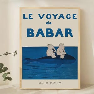 Peut inclure: Une affiche encadrée avec le texte "LE VOYAGE de BABAR" en bleu. L'œuvre représente deux éléphants blancs sur une baleine bleue dans l'eau bleue. Le nom de l'artiste, Jean de Brunhoff, est en bas.