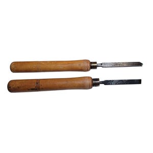 May include: Two wood handled carving tools with metal blades. The tools are both brown and have a natural wood finish.
