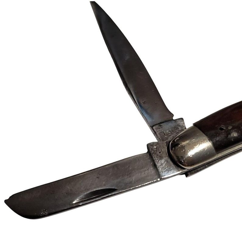 May include: A brown handled pocket knife with two blades, one of which is open. The knife has a silver metal handle and a silver metal bolster.