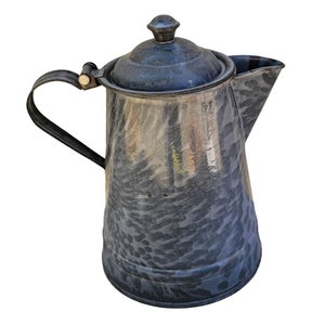 May include: A vintage gray enamel teapot with a speckled pattern and a black handle. The teapot has a lid with a knob on top.