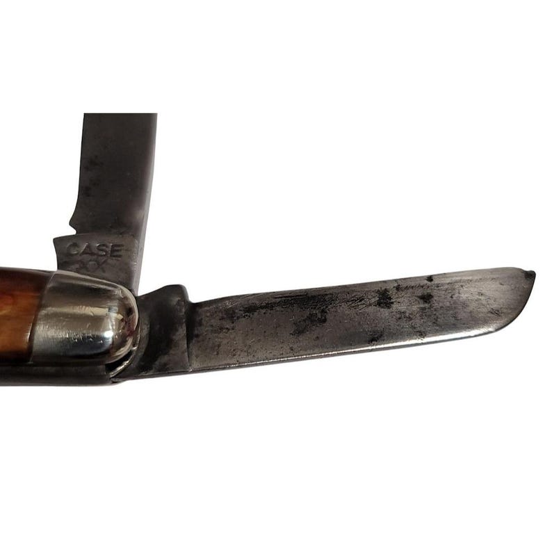 May include: A vintage Case XX pocket knife with a brown wood handle and a partially open blade. The blade is made of metal and has a dull finish.