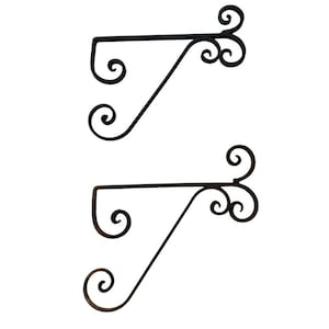 May include: Two black metal wall brackets with a decorative scroll design. The brackets are angled and have a curved shape.