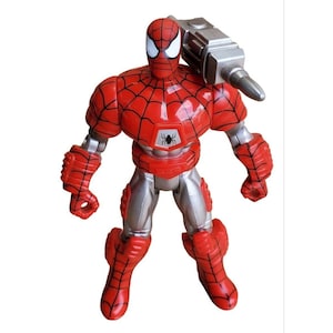 K&ouml;nnte beinhalten: Eine rote und silberne Actionfigur von Spider-Man, die einen metallischen Anzug mit einem Spinnenlogo auf der Brust tr&auml;gt. Die Figur h&auml;lt einen silbernen Bohrer in der rechten Hand.