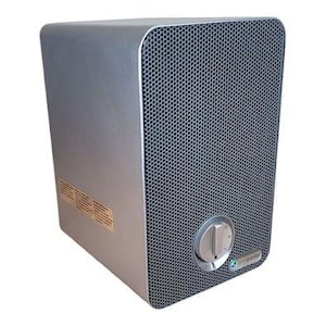 May include: A silver air purifier with a perforated front panel and a control knob. The device has a rectangular shape with rounded corners and a small logo on the lower right corner.