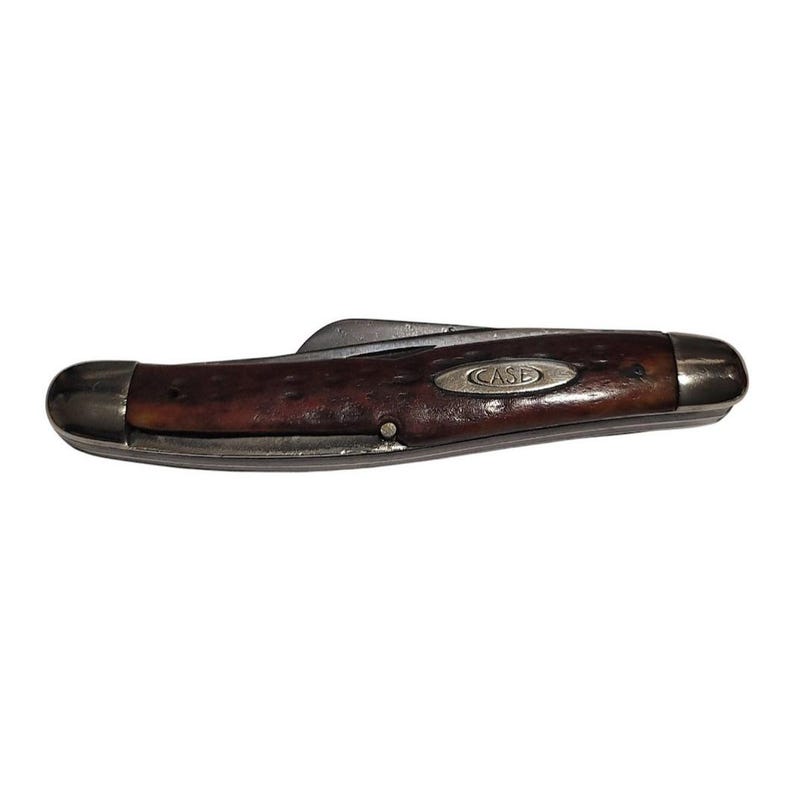 May include: A vintage Case brand pocket knife with a brown wood handle and a silver blade. The knife is closed and has a single blade.