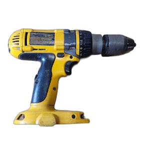May include: A yellow and black cordless power drill featuring a multi-position clutch ring with numbered settings, a black rubberized grip handle, a trigger switch, and a metal chuck at the front for securing drill bits or driver accessories.