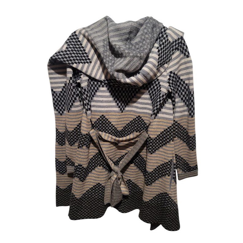 May include: A long-sleeved, black, white, and brown patterned cardigan with a large hood and a tie belt. The cardigan has a chevron pattern.