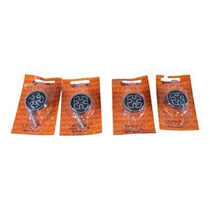 May include: Four decorative cabinet knobs with a black and silver design, packaged on orange cardboard. Each knob has a circular face with a stylized pattern and a silver stem for mounting. The packaging is sealed with clear plastic.