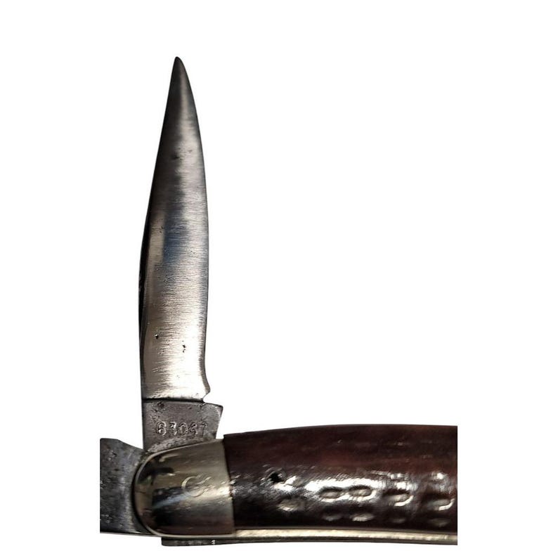 May include: A brown handled pocket knife with a single blade. The blade is open and the handle has the number 87037 stamped on it.