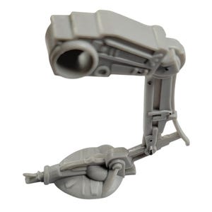 May include: A light gray plastic mechanical component with a curved arm and multiple joints. The part has a cylindrical opening at the top and a rounded base, suggesting a robotic or machine element.