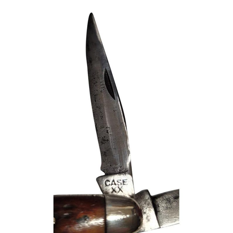 May include: A close-up of a Case XX pocket knife with a brown wood handle and a partially open blade. The blade is marked with the Case XX logo.