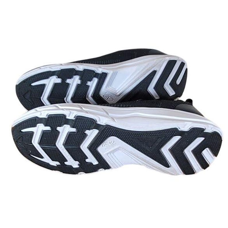 May include: Pair of black and white athletic shoes. The soles are white with black accents and a tread pattern. The uppers are black with a mesh-like texture. The shoes are designed for walking or running.
