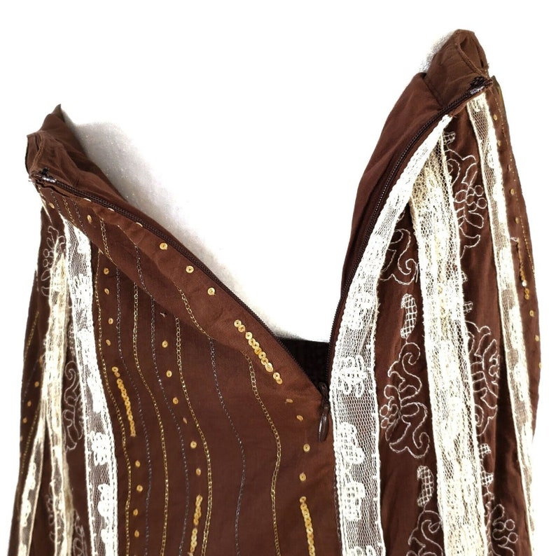 Peut inclure: Jupe marron avec des paillettes dor&eacute;es et une bordure en dentelle blanche. La jupe a une fermeture &eacute;clair et est faite d'un tissu doux et fluide.