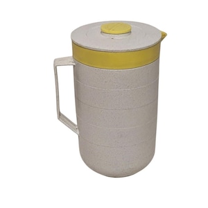 May include: A white pitcher with a yellow lid and handle. The pitcher has a textured surface and a spout on the side.