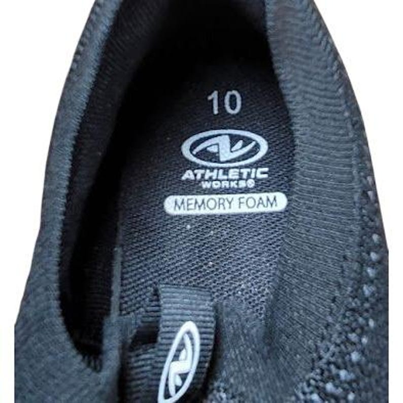 May include: Close-up of the interior of a black athletic shoe. The shoe features the number "10" and the "Athletic Works" logo. The insole is labeled "Memory Foam".