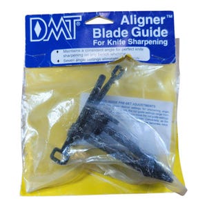 May include: A black knife sharpener guide, packaged in a clear plastic bag with a blue and white label. The label reads "Aligner Blade Guide For Knife Sharpening". The guide has seven angle settings.