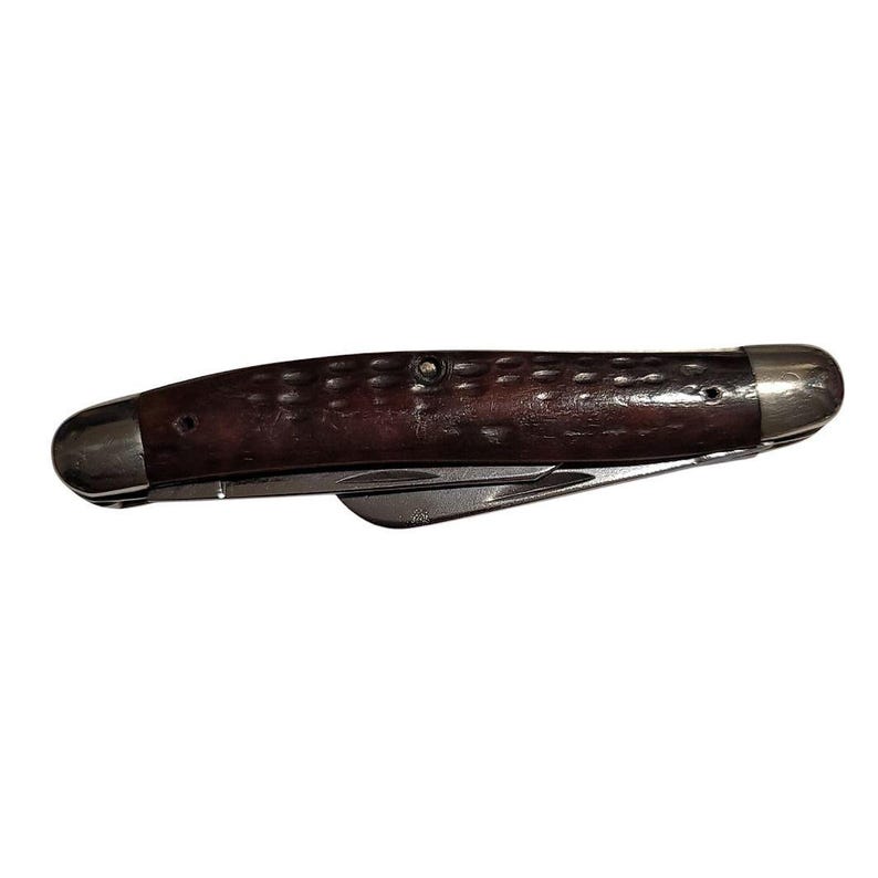 May include: A brown pocket knife with a wood handle and two blades. The knife has a rounded tip and a silver metal frame.