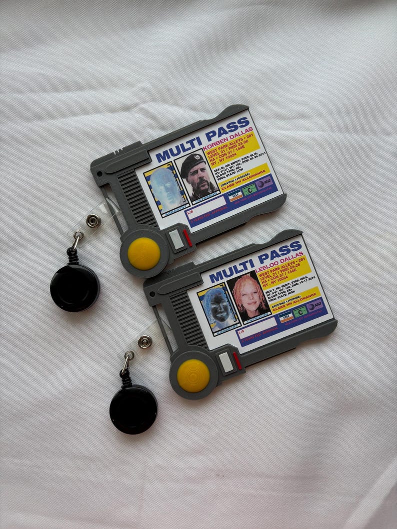 Puede incluir: Dos tarjetas multi-pass de pl&aacute;stico gris con cordones retr&aacute;ctiles. Las tarjetas incluyen una foto, un nombre y una direcci&oacute;n. El texto en las tarjetas dice "MULTI PASS" y "KORBEN DALLAS" y "LEELOO DALLAS".