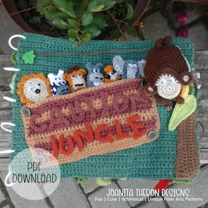 May include: A crocheted jungle-themed baby activity book with a pocket for finger puppets. The book features a lion, zebra, monkey, elephant, and hippo finger puppets. The book is green with brown and orange accents. The text on the book reads "Crochet Jungle".