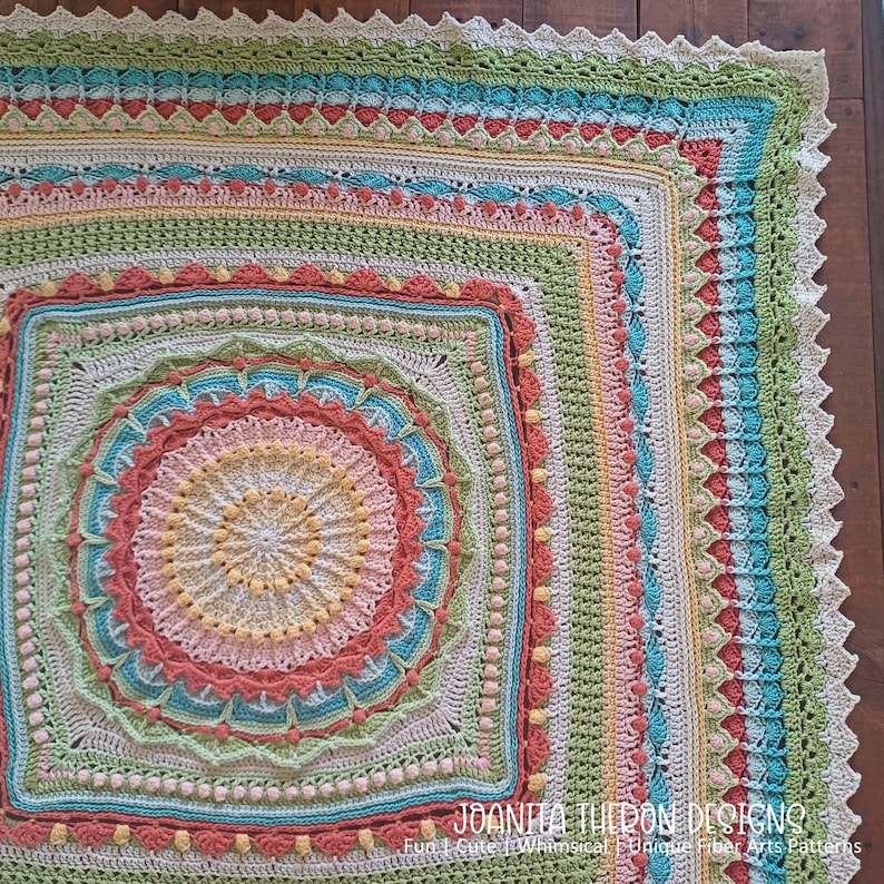 May include: A square, handmade crochet blanket in a variety of pastel colors, including peach, teal, yellow, and green. The blanket features intricate patterns and textures, with a scalloped edge. The text "JOANITA TULON DESIGNS" is visible in the bottom right corner.