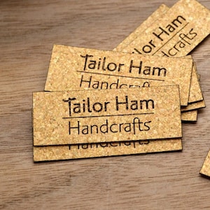 May include: Close-up of five business cards made of cork with the text "Tailor Ham Handcrafts" printed on each card.