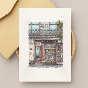Cartolina di viaggio con vetrina di un negozio in Vietnam, porta a casa un pezzo di Asia: incantevole cartolina acquerellata di una casa tradizionale e vetrina di un negozio
