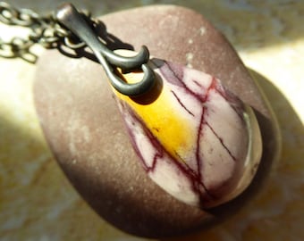 May include: A teardrop-shaped pendant featuring a polished stone with a cream, yellow, and deep purple veined pattern. The stone is held by a dark, oxidized metal bail and is attached to a matching dark metal chain link necklace.
