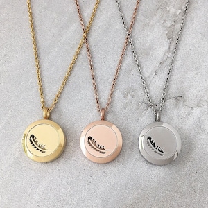 May include: Three silver necklaces with a round pendant featuring a feather design. The necklaces are in gold, rose gold, and silver.