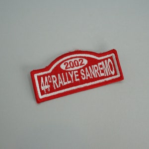 Peut inclure: Patch brodé rouge et blanc avec le texte "44° RALLYE SANREMO 2002".