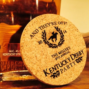 以下が含まれることがあります： 黒い文字で「AND THEY'RE OFF! 20 14 THE MILLER'S 8TH ANNUAL KENTUCKY DERBY PARTY」と書かれた茶色のコルクコースターです。