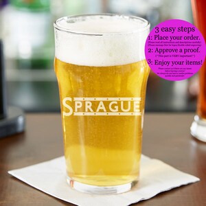May include: A glass of beer with a white foam head in a clear pint glass with the word "SPRAGUE" etched on the side. The glass is sitting on a wooden surface. The image includes instructions for ordering a custom engraved glass: "3 easy steps 1: Place your order. 2: Approve a proof. 3: Enjoy your items!"
