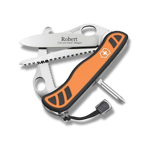 May include: A multi-tool knife with an orange and black handle, featuring a blade, saw, and other tools. The blade is engraved with the name "Robert" and the message "Love you more! -Meagan". The knife is made in Switzerland.