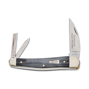 May include: A Case XX pocket knife with a black wood handle and three blades. The main blade is a clip point blade with the inscription "DOUGLAS Protector Hero Father" on the blade. The knife also has a small pen blade and a small sheepsfoot blade.