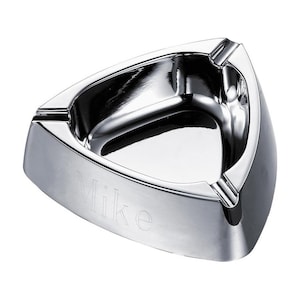 May include: A silver triangular ashtray with a personalized inscription that reads "Mike".