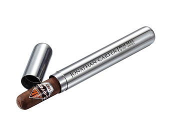 May include: A silver cigar tube with a personalized inscription that reads "JONATHAN CARTER | Best Man 4-27-2020". The tube is open and a brown cigar is partially inside.