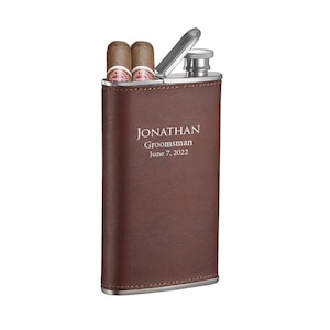 May include: A brown leather-wrapped stainless steel flask with a silver lid. The flask has the text "JONATHAN Groomman June 7, 2022" engraved on the front.