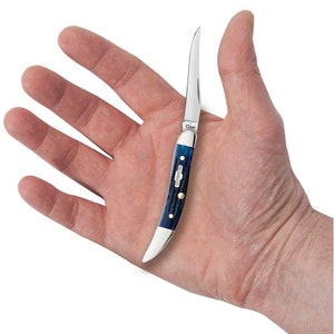 K&ouml;nnte beinhalten: Ein kleines Taschenmesser mit einem blauen Knochengriff und einer einzelnen Klinge. Das Messer ist ge&ouml;ffnet und wird in einer Hand gehalten.