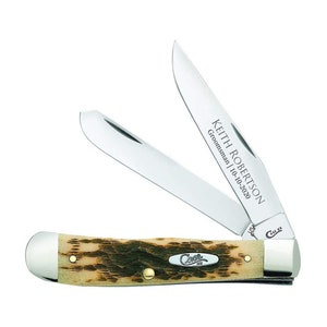 May include: A Case XX pocket knife with a brown and tan bone handle. The blade is open and engraved with the text "Keith Robertson,  Groomsman | 10-10-2020".