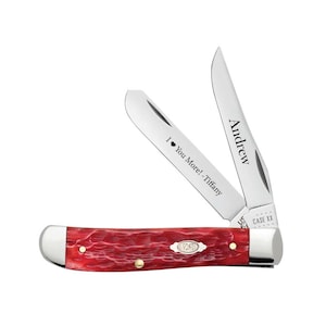 May include: A red pocket knife with two open blades. The blades are engraved with the names "Andrew" and "I ❤️ You More! - Tiffany". The knife has a textured handle and a silver bolster. The Case XX logo is visible.