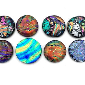 May include: Eight round iridescent glass cabochons with various patterns and colors, including blue, green, purple, and orange.