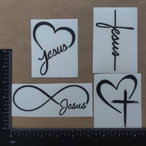 May include: Four black vinyl decals with different designs featuring the word "Jesus". The designs include a heart, a cross, an infinity symbol, and a heart with a cross.